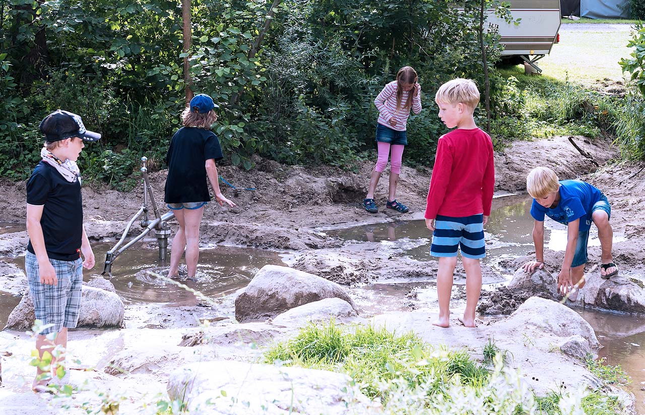 Kinder spielen mit Wasser im Abenteuerwald