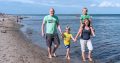 Familie geht Hand in Hand am Ostseestrand