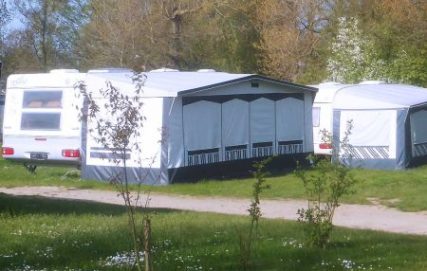 Mietwohnwagen auf Rasen mit Vorzelt